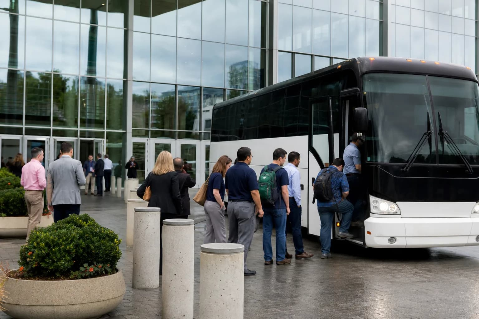 People boarding a white coach outside a convention centre entrance